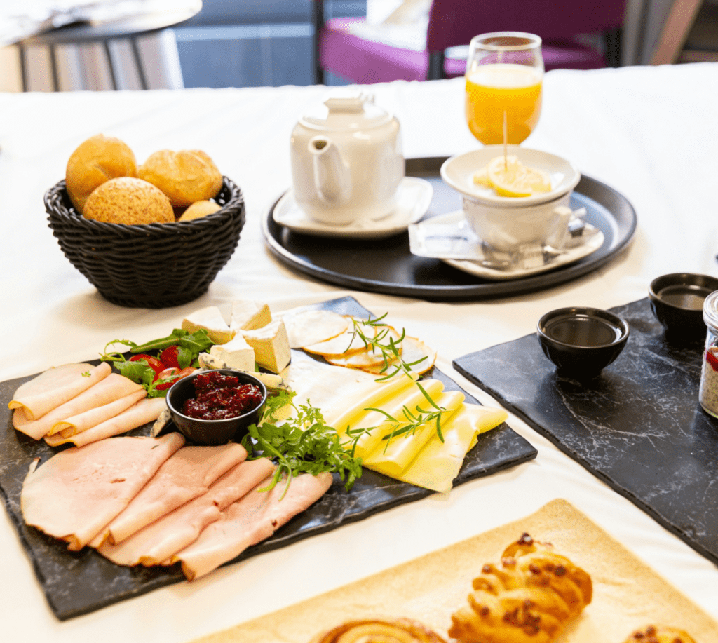 Hotelfrühstück mit Kaffee, Tee, Orangensaft, Gebäck, Käse und Aufschnitt